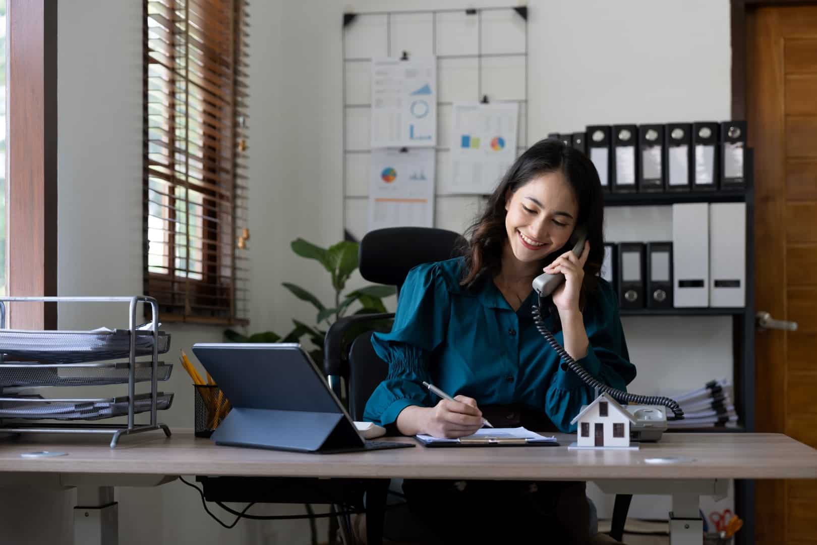 female real estate broker on phone call at her desk